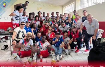 Éver Almeida (d) posa con los jugadores del El Nacional en vestuario celebrando la victoria.