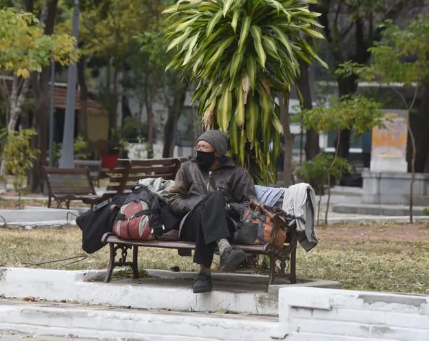 Imagen de archivo y referencia: un hombre abrigado sentado en una plaza de Asunción.