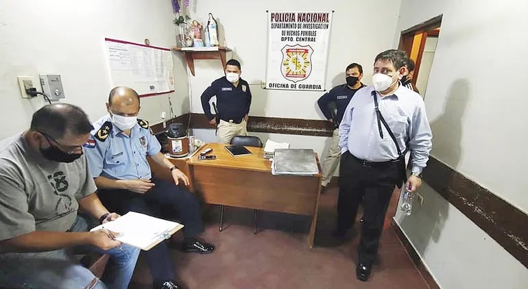 El fiscal Federico Delfino (parado) y el comisario general Gilberto Fleitas (sentado) aparecen en la oficina de guardia del departamento de Investigaciones de Central, allanado ayer en San Lorenzo.