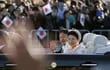 El emperador Naruhito y la emperatriz Masako saludan a la multitud durante el desfile de este domingo en Tokio.
