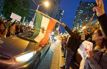 Manifestantes con banderas de Irán protestan en Toronto, Canadá.