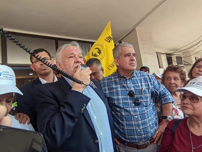 El titular del IPS Jorge Brítez y el representante del gremio de jubilados durante una reunión con los mismos ayer frente a la sede administrativa del IPS