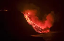 La colada de lava que emerge de la erupción volcánica de La Palma ha llegado en la noche del martes al mar en una zona de acantilados situados en las cercanías de la playa El Guirre, en Tazacorte. EFE/Ángel Medina