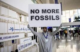 Un activista con un cartel pidiendo el fin de los combustibles fósiles protesta en Dubái, el pasado miércoles.