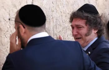 El presidente Javier Milei (d), emocionado, llora, junto al rabino Shimon Axel Wahnish, ante el Muro de los Lamentos.