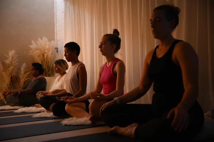 Practicantes de yoga asisten a una sesión en un estudio al este de Londres, Reino Unido.