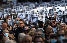 Relatives of victims of a bomb attack to the Jewish community centre of the Mutual Israelite Association of Argentina (AMIA) that killed 85 people and injured 300, hold photos during its 28th anniversary, in Buenos Aires, Argentina, on July 18, 2022. (Photo by Luis ROBAYO / AFP)