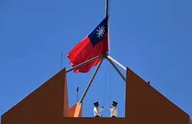 Personal militar de la embajada de Taiwán en Honduras comenzaron a arriar su bandera nacional.  (AFP)