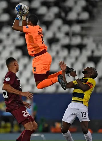 Wuilker Fariñez, arquero de Venezuela,  vuela para capturar un balón en su área ante la presencia del delantero ecuatoriano Enner Valencia, durante el partido disputado anoche en Río de Janeiro.