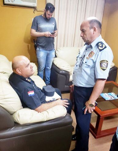 El comisario René Alberto Aquino Girett (sentado) escucha al comisario general Miguel Cañiza, tras ser arrestado en Alto Paraná.