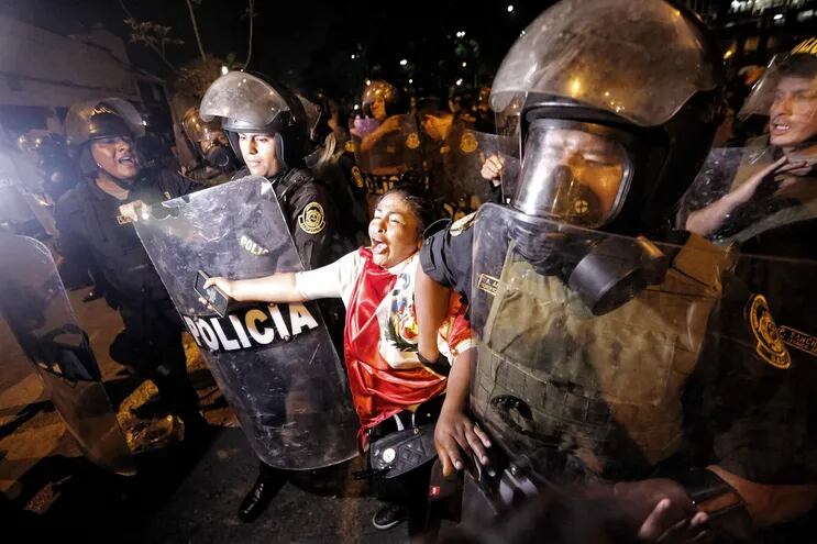 Policías detienen a una ciudadana que protesta contra el Gobierno de Dina Boluarte, en Lima (Perú).