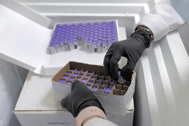 Un trabajador médico desembala una caja de viales de vacuna contra el coronavirus Pfizer-BioNTech COVID-19 de un refrigerador en un centro de vacunación (Imagen ilustrativa).