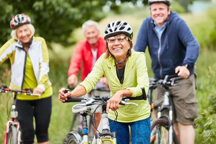Un grupo de adultos mayores realiza un paseo en bicicleta.