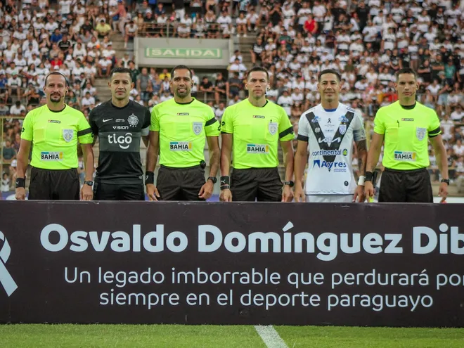 Los capitanes de Olimpia y Sportivo Ameliano posan con los árbitros en la previa del partido por la cuarta fecha del torneo Apertura 2024 del fútbol paraguayo en el estadio Villa Alegre, en Encarnación.