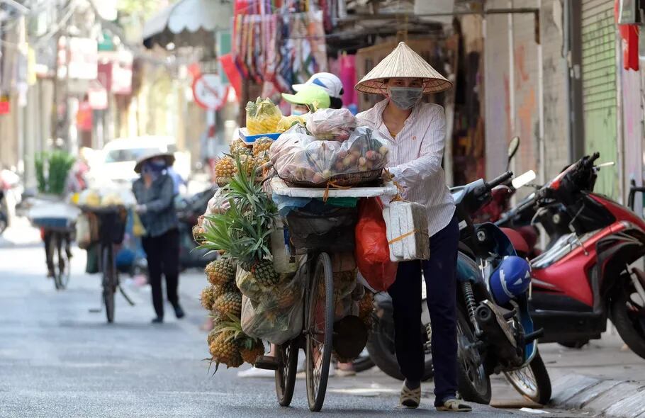 Con su carga a cuestas, un vendedor ambulante vietnamita usa su bicicleta para transportar su mercancía.