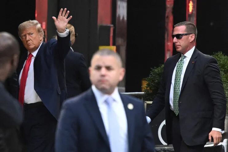 El expresidente de EE.UU., Donald Trump, (i) saluda a sus seguidores apostados frente al edificio Trump Tower en New York. (AFP)