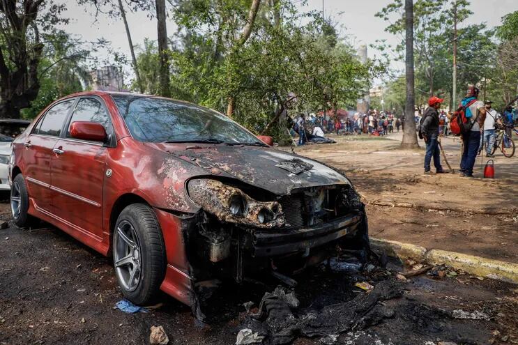 Vista hoy de un automóvil incinerado durante disturbios frente al Congreso Nacional.