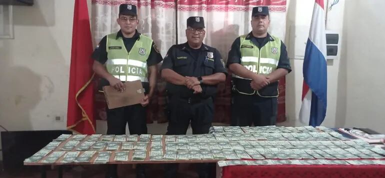 Policías posan con el dinero encontrado y recuperado.