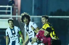 El arquero de Tacuary, Aldo Bareiro atrapa el balón ante las  miradas de Walter González y Édgar Benítez (4) y Ronal Domínguez (8).