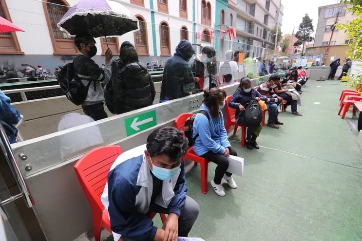 Varios ciudadanos esperan en un punto de vacunación autorizado para recibir una dosis de refuerzo de la vacuna contra la COVID-19, en La Paz.
