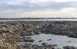 Neumáticos, latas, restos de cartón, botellas y bolsas plásticas constituyen los residuos que el río Paraguay dejó al descubierto, cuando abandonó la costa de la ciudad de San Antonio debido de la sequía.