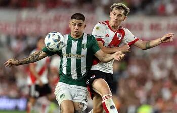 Banfield's defender Aaron Quiros (L) vies for the ball with River Plate's forward Facundo Colidio during the Argentine Professional Football League Cup 2024 match at El Monumental stadium in Buenos Aires on February 18, 2024. (Photo by ALEJANDRO PAGNI / AFP)