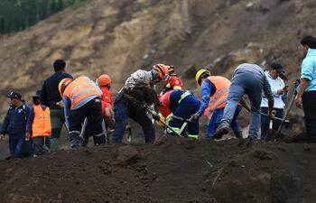 Pobladores y rescatistas buscan a víctimas de un alud, en Alausí, Ecuador.
