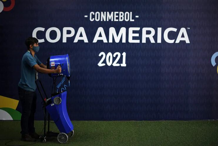 A Conmebol staff member performs cleaning and disinfection tasks ahead of the 2021 Copa America football match between Uruguay and Chile, at the Arena Pantanal in Cuiaba, Mato Grosso state, Brazil, on June 21, 2021. (Photo by DOUGLAS MAGNO / AFP)