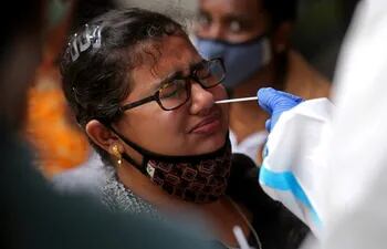 Un trabajador sanitario toma una muestra en busca de COVID-19 en India.