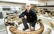 Mat Wooller, director de la Instalación de Isótopos Estables de Alaska, arrodillado entre una colección de algunos de los colmillos de mamut en el Museo del Norte de la Universidad de Alaska.