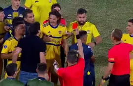 El paraguayo José Arrúa (remera negra) recibe la tarjeta roja después de discutir con Edinson Cavani y empujar a Miguel Merentiel.