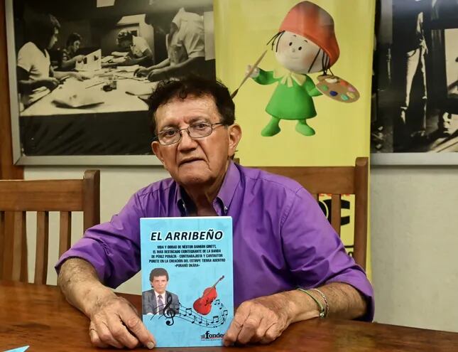 El cantante y compositor Néstor Damián Girett exhibe la portada de su libro "El arribeño".