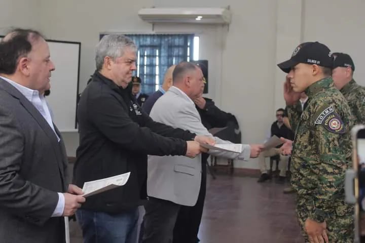 El ministro del Interior Enrique Riera y el gobernador de Ñeembucú, Victor Hugo Fornerón entregan el certificado a los suboficiales egresados.