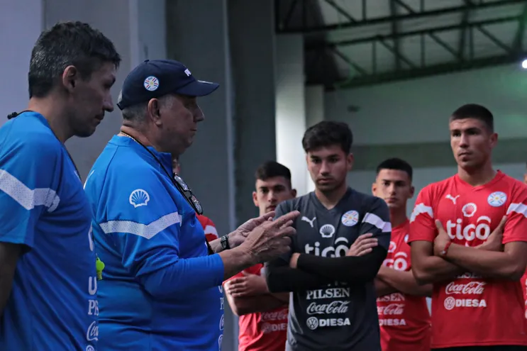 Carlos Jara Saguier (quepis), entrenador de la selección paraguaya, conversa con los jugadores en el entrenamiento en el CARDE de Ypané.