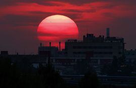 El sol se oculta tras un edificio a las afueras de Zaragoza, España.