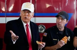 "En la jornada de la venganza de Trump en Iowa, que compró pizzas a sus militantes, sólo en la calle hacía frío". (Foto: AP)