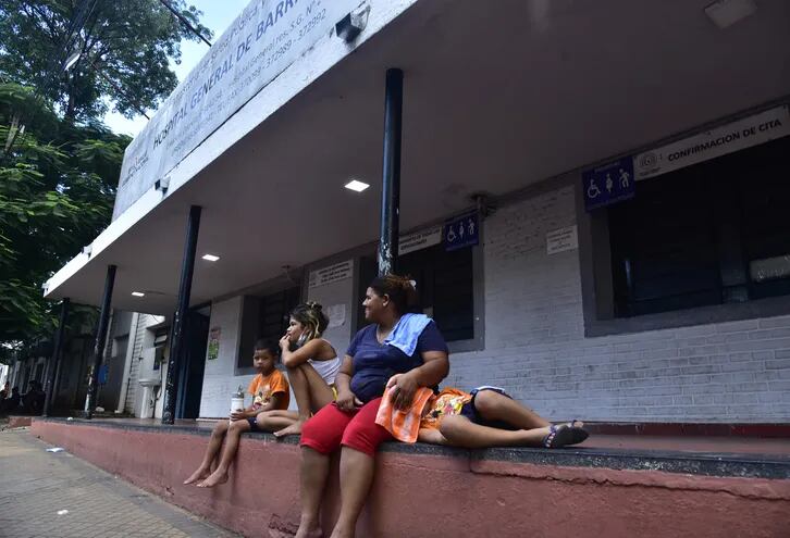 Una mujer aguarda atención médica con sus tres hijos, frente al Hospital General de Barrio Obrero. Los niños son mayoría en cuanto a internados por dengue.