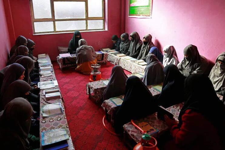 En una escuela coránica de Kabul, un grupo de adolescentes sentadas en fila se balancean de atrás a adelante recitando versículos del Corán, bajo la mirada atenta de su instructora.