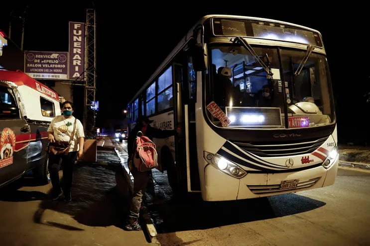 Un pasajero sube a un bus en horario nocturno-madrugada en Asunción.
