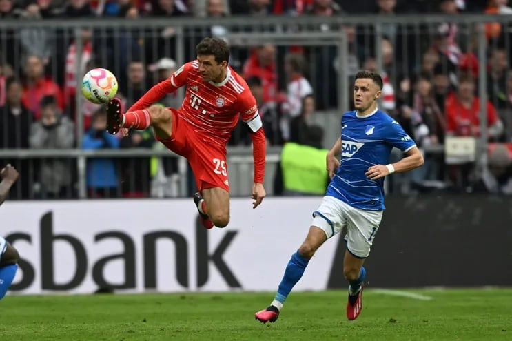 Thomas Müller, del Bayern Munich, salta en procura de controlar el balón ante la presencia de un jugador del Hoffenheim, durante el partido que empataron 1-1.