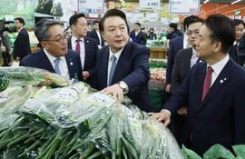 El presidente de Corea del Sur,  Yoon Suk Yeol (C) durante una visita a un mercado popular en Seúl. Mañana renuevan bancas en el legislativo.