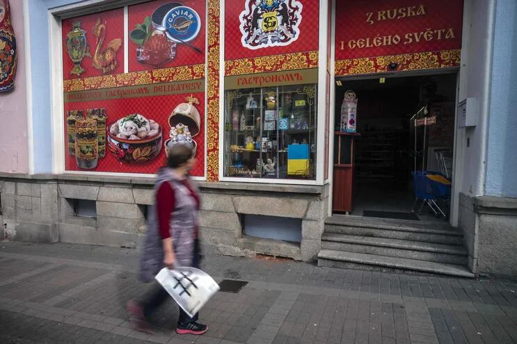 Una mujer pasa frente a una tienda rusa en Karlovy Vary, República Checa. Las ciudades balneario checas que figuran en la lista de la UNESCO están buscando clientes luego de una disminución dramática en su clientela extranjera debido a la pandemia de Covid y la guerra de Rusia contra Ucrania.