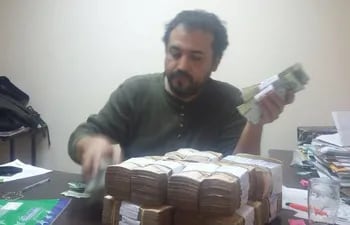 Víctor Ocampos, funcionario de la Municipalidad de Asunción, cuenta fajos de dinero.