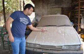 Cristian Cristaldo muestra la gran cantidad de polvo sobre un vehículo estacionado en su casa.