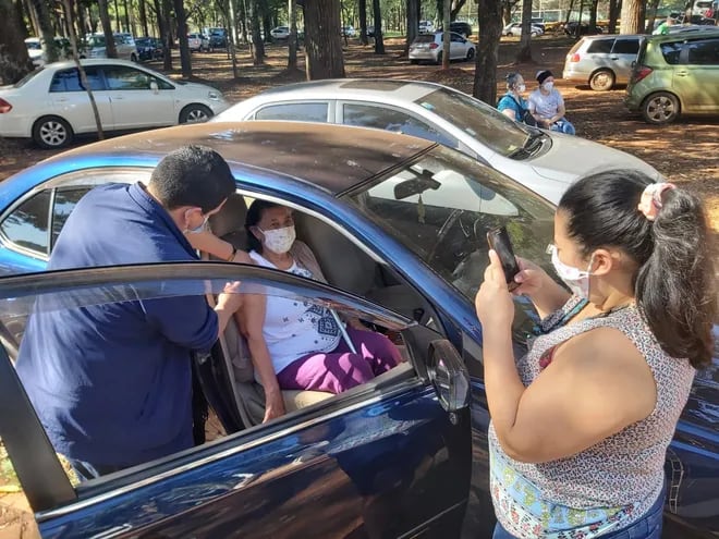 Un vacunador aplica la dosis a una personas dentro de sus auto, en la Gobernación del Alto Paraná.