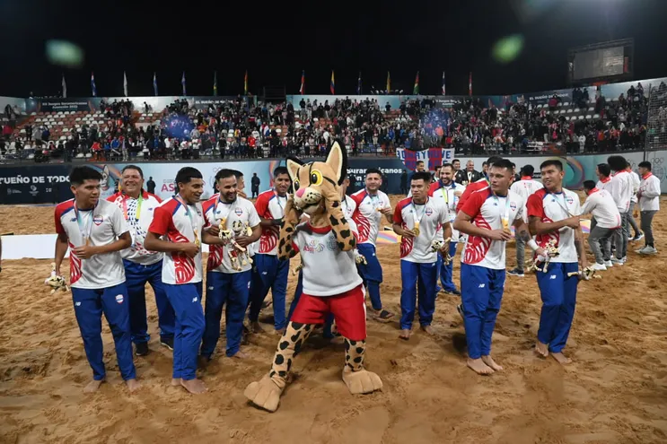 Los jugadores de la selección paraguaya de Fútbol Playa festejando la medalla de oro con Tirika, la mascota de los Juegos Odesur Asunción 2022.