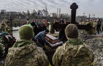 Familiares, amigos y compañeros de Dmytro y Kirilo, dos de los tres soldados ucranianos muertos en combate, participan este miércoles en su entierro en el Cementerio de Lychakiv en Leópolis. (EFE/Borja Sánchez Trillo)