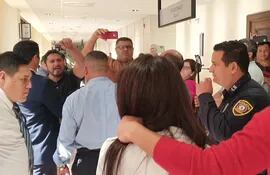 Elvio Barúa (de frente, a la izquierda) grita a la abogada Amambay Ferreira, en los pasillos del Poder Judicial.