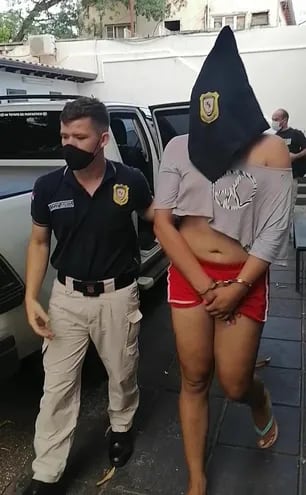 Un agente policial acompaña a la detenida.