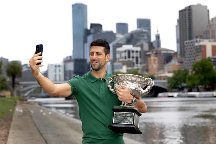 El serbio Novak Djokovic posa con el trofeo del Abierto de Australia, torneo de Grand Slam que ganó con una lesión de desgarro de tres centímetros.